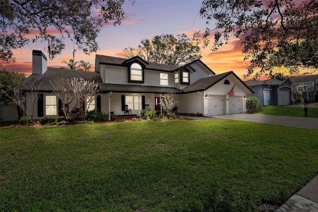 view of front of property with a garage, covered porch, and a lawn