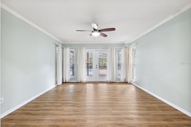 empty room with french doors, ceiling fan, ornamental molding, and light hardwood / wood-style flooring