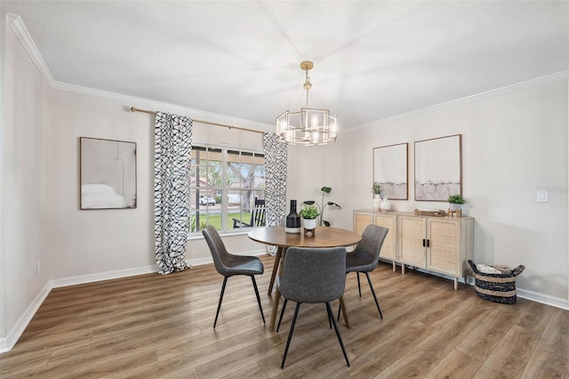 dining room with hardwood / wood-style flooring, ornamental molding, and a chandelier