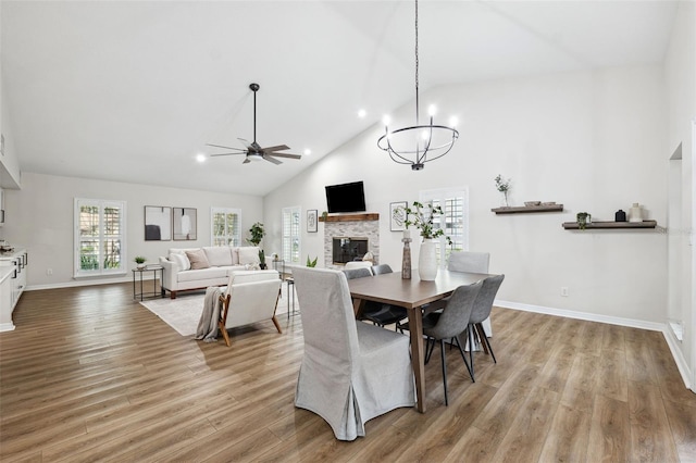 dining area with ceiling fan, high vaulted ceiling, and light hardwood / wood-style flooring