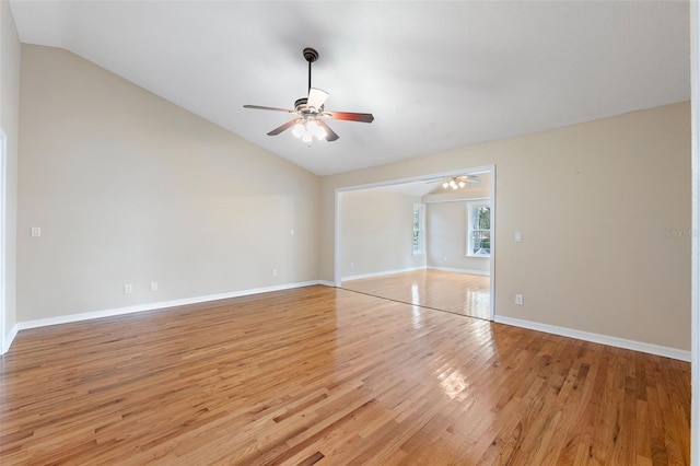 empty room with vaulted ceiling, ceiling fan, and light wood-type flooring