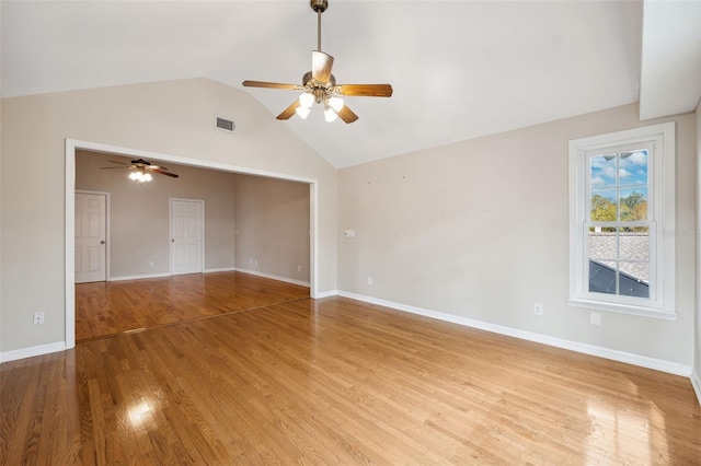 empty room with ceiling fan, vaulted ceiling, and light hardwood / wood-style flooring