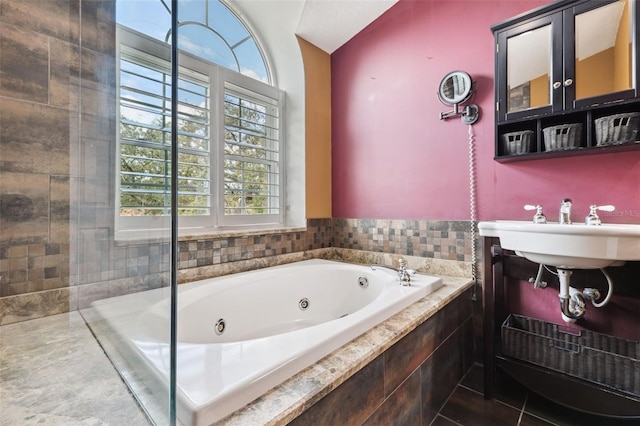 bathroom featuring tiled tub and sink