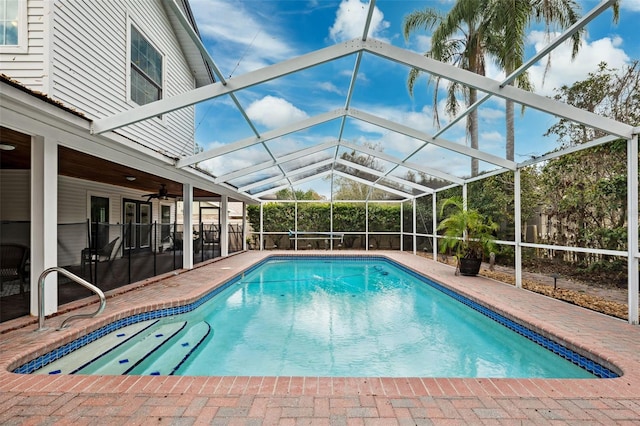 view of swimming pool featuring a lanai, a patio area, and ceiling fan