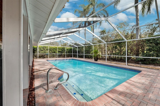 view of pool with a patio area and glass enclosure