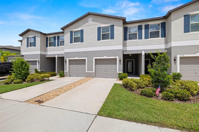 view of property with concrete driveway, an attached garage, and stucco siding