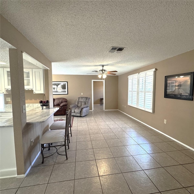 office area featuring tile patterned flooring, ceiling fan, and a textured ceiling