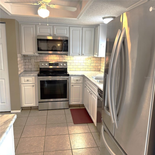 kitchen with white cabinetry, decorative backsplash, stainless steel appliances, and a textured ceiling