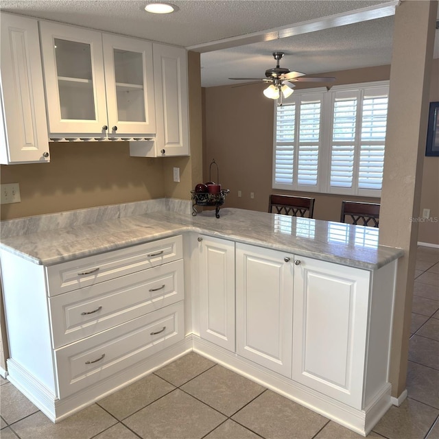 kitchen featuring white cabinetry, light tile patterned flooring, and kitchen peninsula