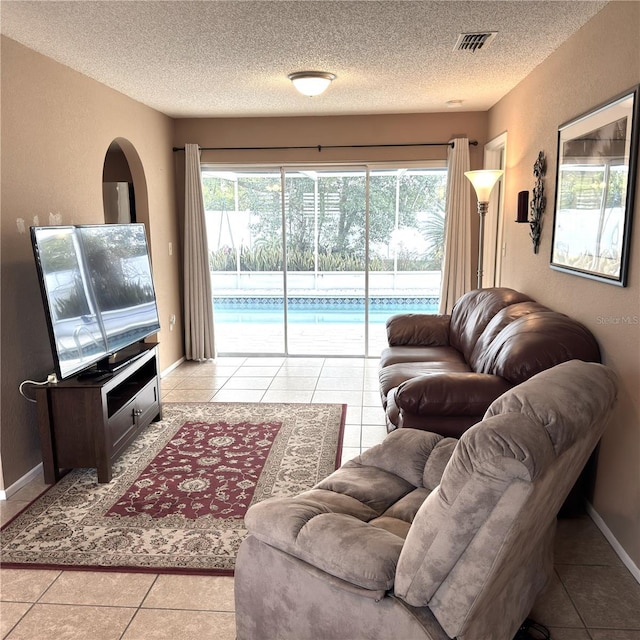 tiled living room featuring a textured ceiling