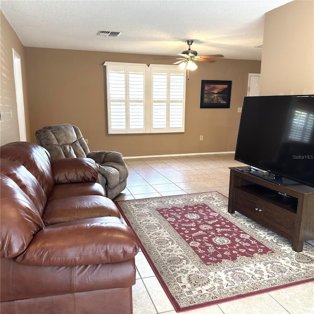 tiled living room with ceiling fan and a textured ceiling