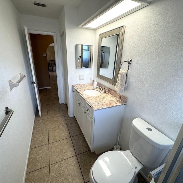 bathroom with vanity, toilet, and tile patterned flooring