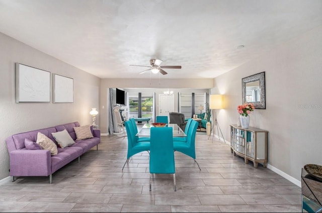 living room featuring ceiling fan with notable chandelier