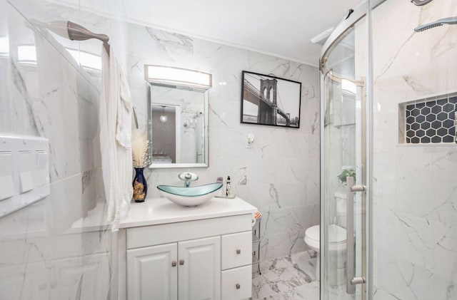 bathroom featuring vanity, a shower with door, tile walls, and toilet