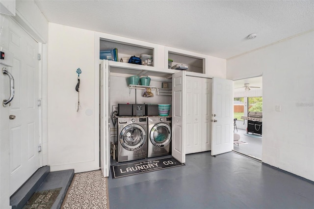 laundry area featuring washing machine and clothes dryer and a textured ceiling