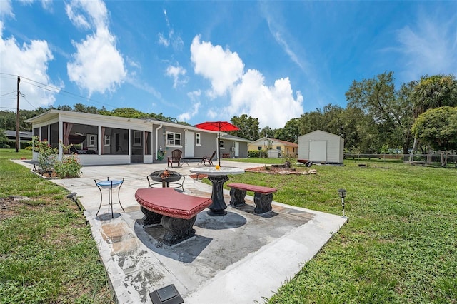 exterior space with an outdoor fire pit, a storage unit, and a sunroom