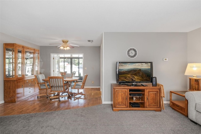 carpeted dining room with ceiling fan