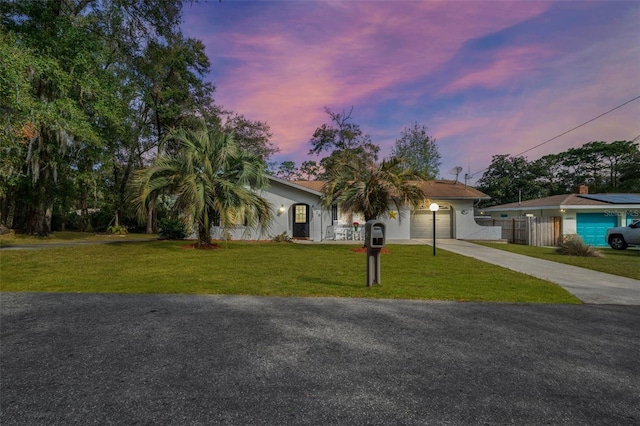 view of front of home with a garage and a yard