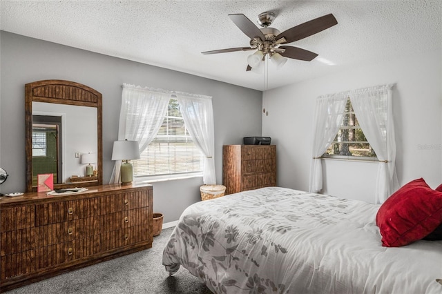 bedroom with light carpet, ceiling fan, and a textured ceiling