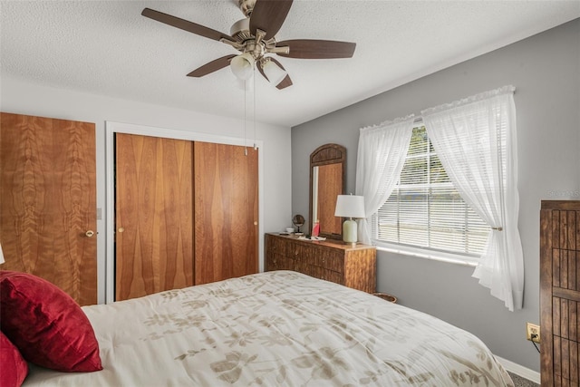 bedroom with ceiling fan, a textured ceiling, and a closet