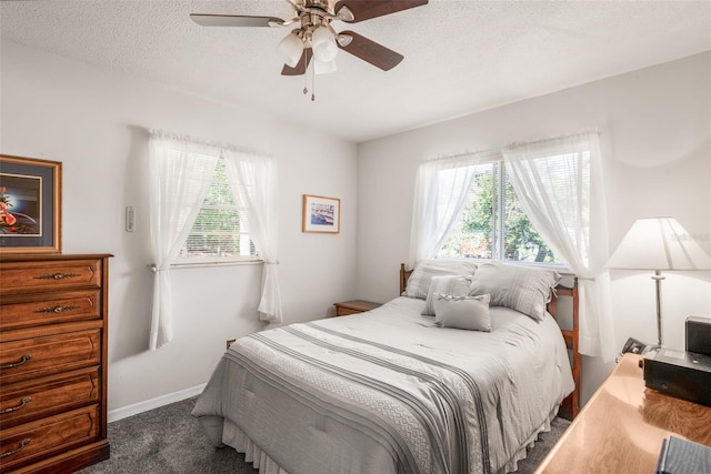 bedroom featuring ceiling fan, a textured ceiling, and dark colored carpet