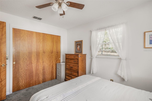 bedroom featuring a textured ceiling, a closet, ceiling fan, and carpet flooring