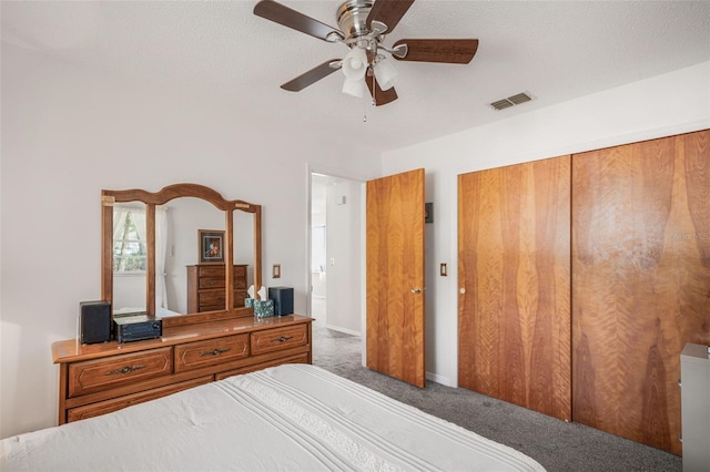 bedroom with dark colored carpet, a textured ceiling, ceiling fan, and a closet