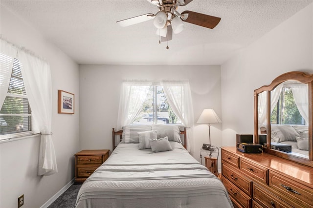 carpeted bedroom with multiple windows, ceiling fan, and a textured ceiling