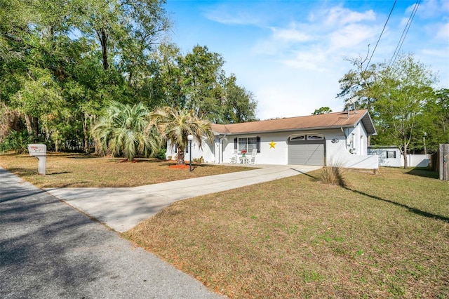 ranch-style home with a garage and a front lawn