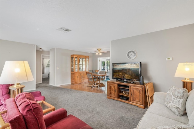 living room with ceiling fan and carpet