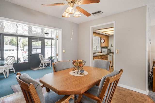 dining room with sink, ceiling fan, and light hardwood / wood-style flooring