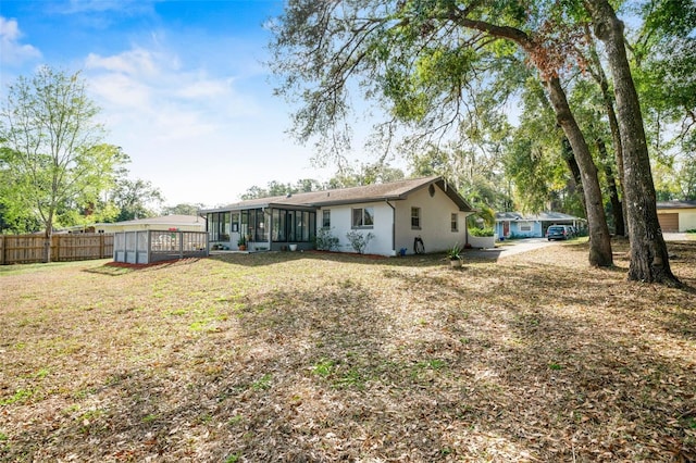 rear view of house with a sunroom and a lawn