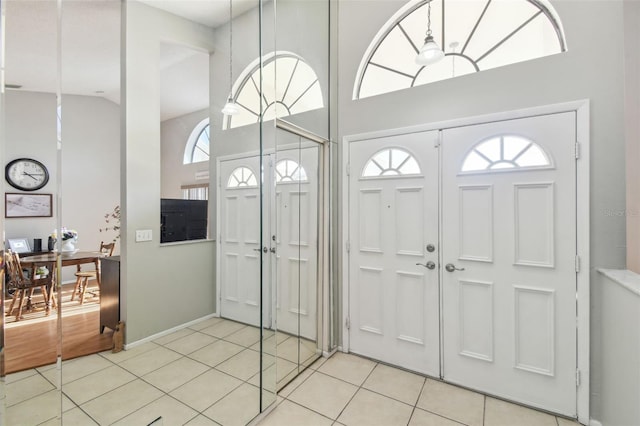 tiled foyer featuring high vaulted ceiling