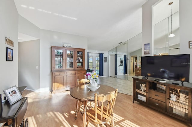 dining area featuring vaulted ceiling and light wood-type flooring