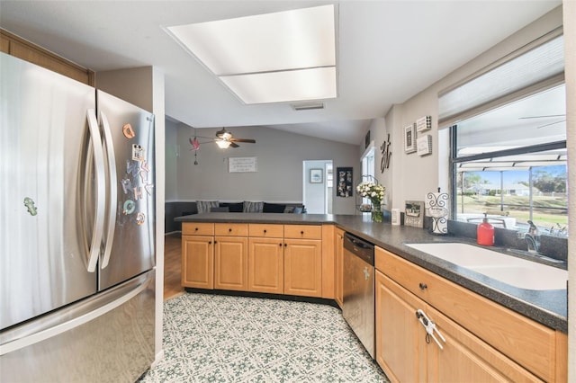 kitchen with vaulted ceiling, sink, ceiling fan, kitchen peninsula, and stainless steel appliances