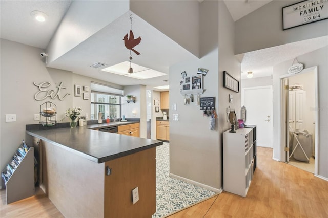 kitchen featuring dishwasher, light hardwood / wood-style flooring, and kitchen peninsula