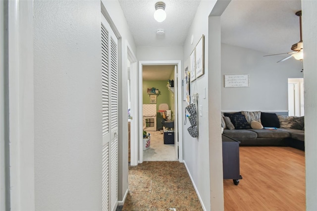 hall with hardwood / wood-style floors and a textured ceiling