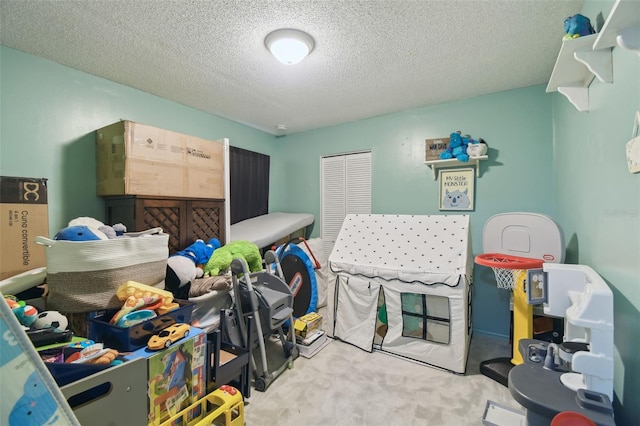 playroom featuring carpet floors and a textured ceiling