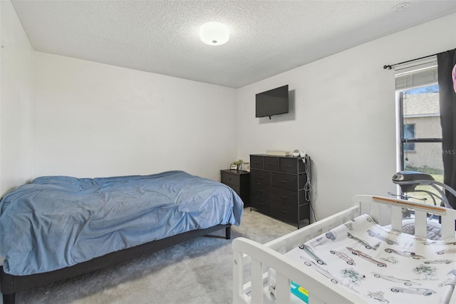 bedroom featuring light carpet and a textured ceiling