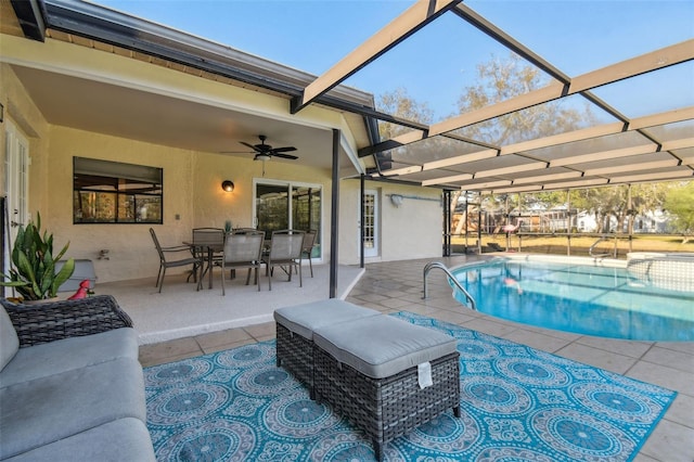 view of swimming pool with ceiling fan, glass enclosure, and a patio area