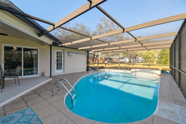 view of swimming pool featuring a patio area, an in ground hot tub, and glass enclosure