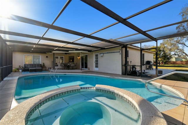 view of swimming pool with an in ground hot tub, a lanai, a patio area, and french doors