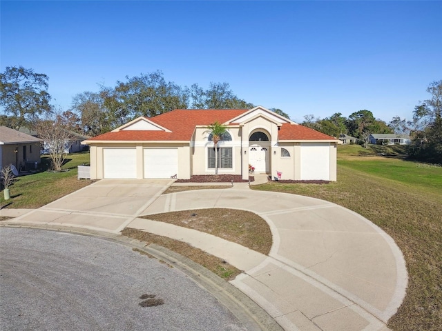 mediterranean / spanish-style home with a garage and a front lawn