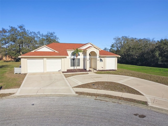 mediterranean / spanish-style home with a garage and a front yard