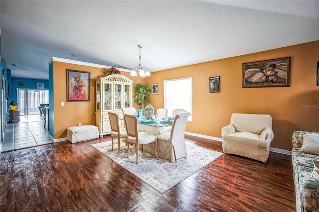 dining area with hardwood / wood-style floors, a textured ceiling, and a notable chandelier