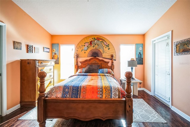 bedroom featuring dark hardwood / wood-style flooring and a textured ceiling