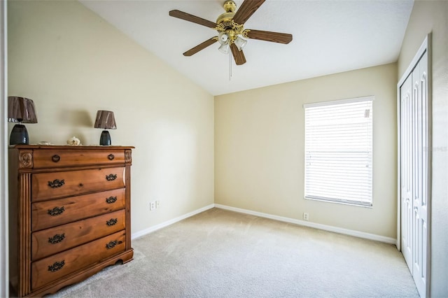 unfurnished bedroom with lofted ceiling, light colored carpet, ceiling fan, and a closet