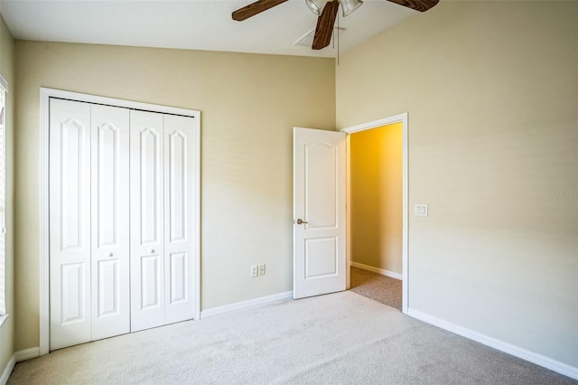 unfurnished bedroom featuring lofted ceiling, light colored carpet, ceiling fan, and a closet