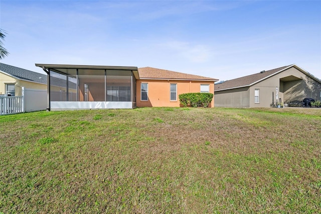 back of house with a yard and a sunroom