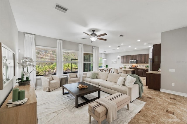 living room featuring a healthy amount of sunlight and ceiling fan